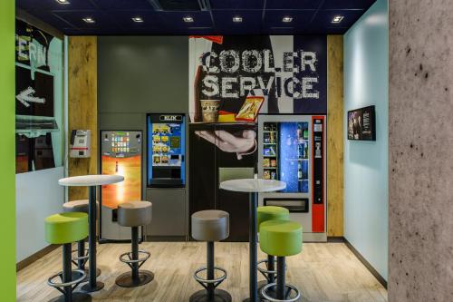 a coffee shop with stools and a vending machine at Ibis Budget Salzburg Airport - Self-Check-In in Salzburg