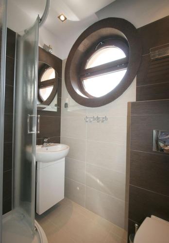 a bathroom with a toilet and a sink and a window at Apartamenty z widokiem na Zalew in Krynica Morska