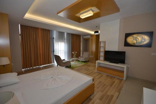 a bedroom with a large bed and a television at Hotel Veri in Peshkopi