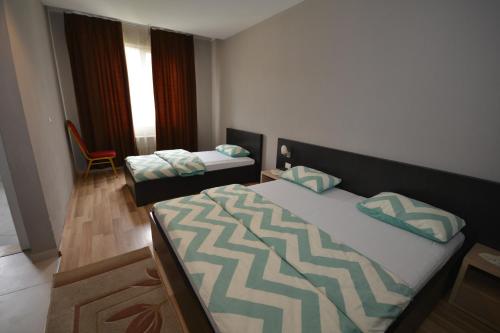 a bedroom with two beds and a chair at Hotel Veri in Peshkopi