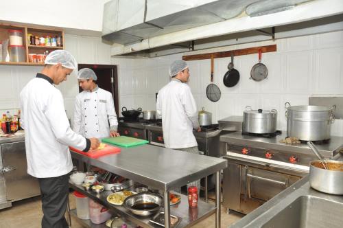 a group of chefs preparing food in a kitchen at Mandala Hotel Kathmandu in Kathmandu