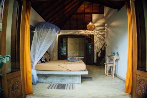a bedroom with a bed with a mosquito net at SURF N SUN - Arugam Bay in Arugam Bay