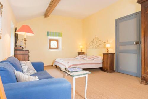a living room with a bed and a blue couch at Domaine Grand Guilhem in Cascastel-des-Corbières