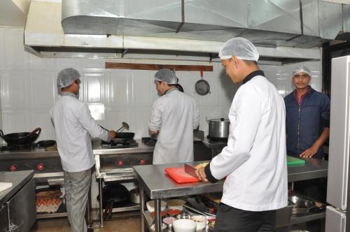 a group of men in a kitchen preparing food at Mandala Hotel Kathmandu in Kathmandu