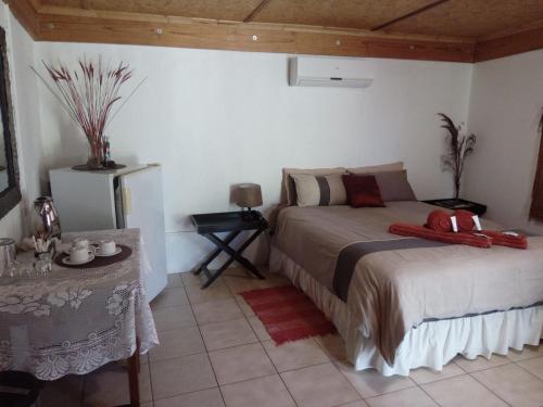 a bedroom with a bed and a table at Xain Quaz Camp in Gobabis