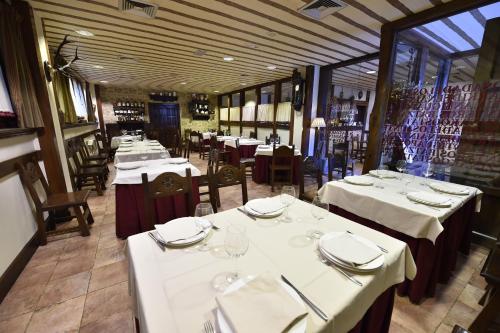 een eetkamer met tafels met witte tafelkleden bij Batzarki in Avellaneda