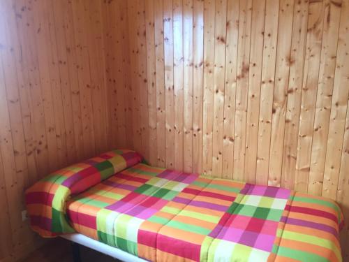 Cama en habitación con pared de madera en Casa Rural Cuesta Grande en Pelabravo