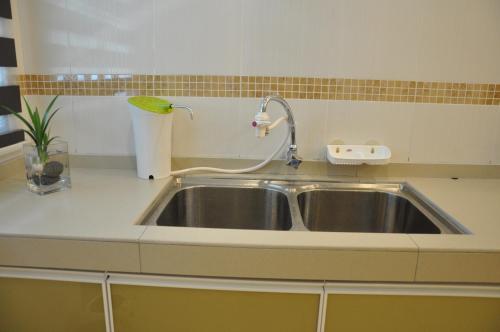 a kitchen sink with a faucet on top of it at Imperial Cottage in Melaka