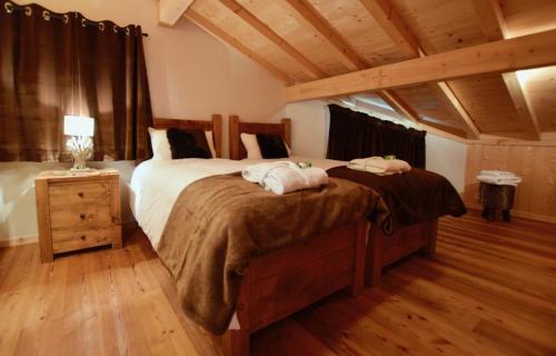 a bedroom with two beds and a wooden floor at Chalet Imperial in Morzine