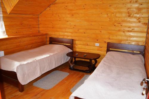 um quarto com duas camas e uma mesa num camarote em Guest House U Stasuka em Vorokhta