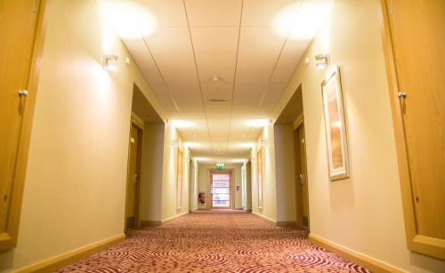 an empty hallway in a hospital with lights on the ceilings at Curran Court Hotel in Larne