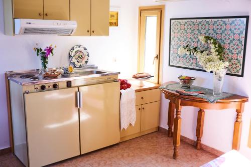 a kitchen with a stainless steel refrigerator and a table at Vamos Palace Apartments in Vamos