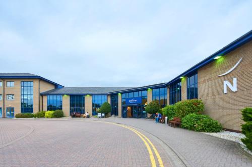 a building with a sign on the side of it at Novotel London Stansted Airport in Stansted Mountfitchet