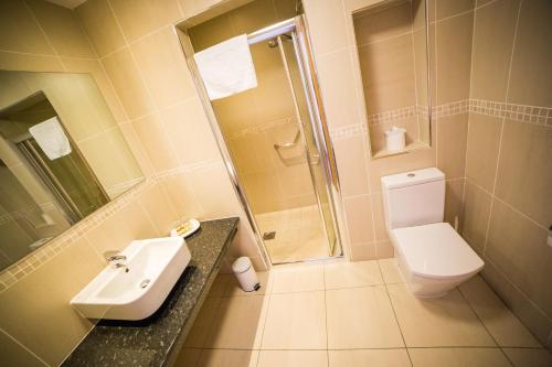 y baño con lavabo, aseo y ducha. en Curran Court Hotel en Larne