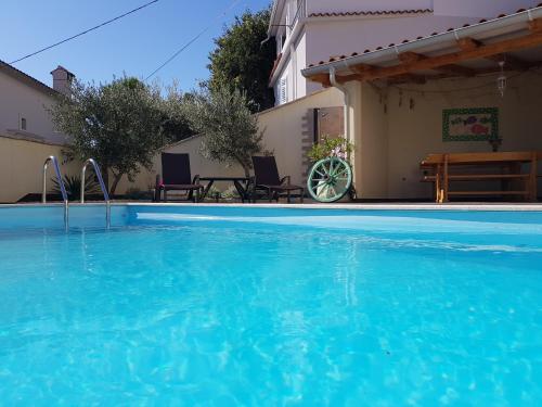 a swimming pool in front of a house at Villa Chiara in Brseč
