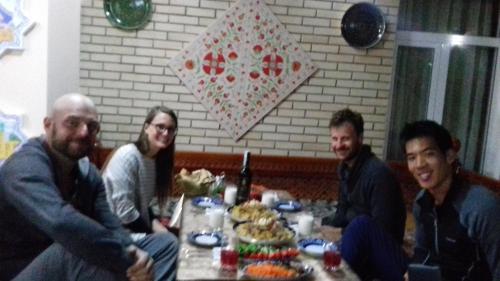 een groep mensen die rond een tafel zitten bij Yasmin in Bukhara