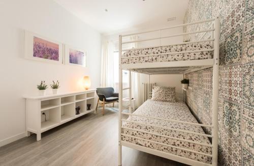 - une chambre avec 2 lits superposés et un bureau dans l'établissement Living Guzman Apartment, à Madrid