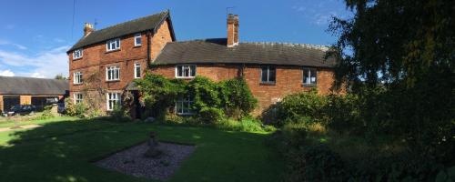 a large brick house with a yard in front of it at Mackworth House Farm in Derby