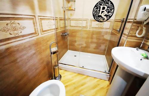 a bathroom with a shower with a toilet and a sink at Black Sea Star Batumi in Batumi