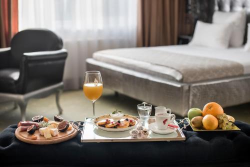 a hotel room with a tray of food and a glass of wine at Weekend Boutique Hotel in Chişinău