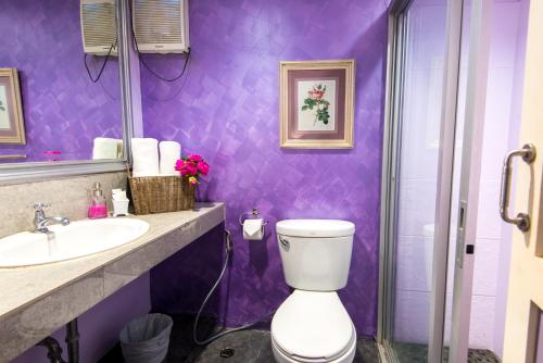 a purple bathroom with a toilet and a sink at Lilac Relax-Residence in Lat Krabang