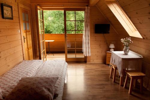 1 dormitorio con cama, mesa y ventana en Pokoje gościnne "Mraźnica" en Zakopane