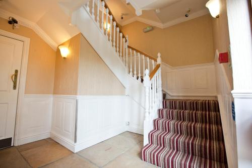 a staircase in a home with orange walls at Marygreen Manor in Brentwood