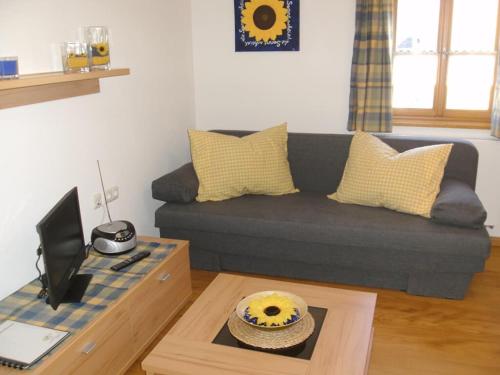 a living room with a couch and a table with a cake at Zum Egerländer Fachwerkhof in Neualbenreuth