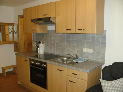 a kitchen with wooden cabinets and a sink at Zum Egerländer Fachwerkhof in Neualbenreuth