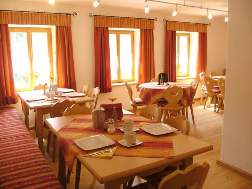 a dining room with tables and chairs and windows at Zum Egerländer Fachwerkhof in Neualbenreuth