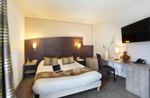um quarto de hotel com uma cama grande e uma secretária em B&B HOTEL Montbéliard-Sochaux em Sochaux