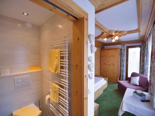 a bathroom with a room with a couch and a bed at Pension Cafe Fritz in Lech am Arlberg