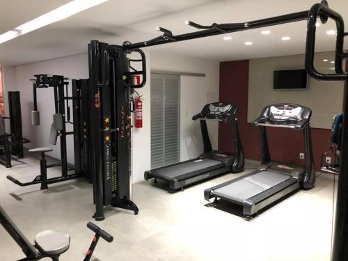 a gym with several tread machines in a room at Verona Tower Hotel in Divinópolis