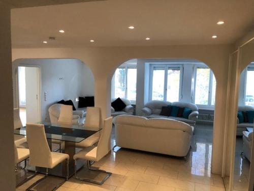 a living room with a couch and a table and chairs at Ferienwohnung Amperblick Fürstenfeldbruck in Fürstenfeldbruck
