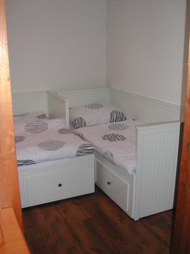 two white beds in a room with wooden floors at Haus Polly in Strasshof an der Nordbahn