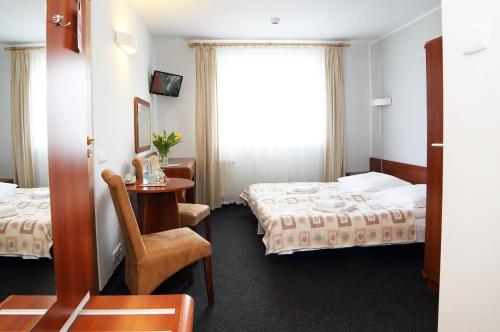 ビストシツァ・クウォツカにあるHotel i Restauracja ABISのベッド2台とテーブルが備わるホテルルームです。