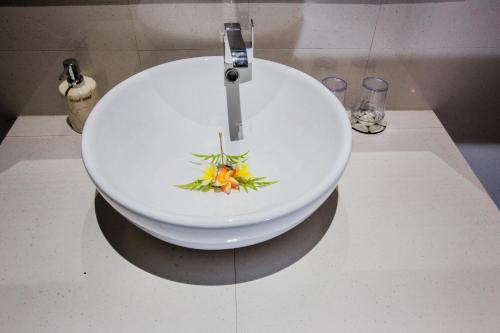 a sink with a bowl with a flower on it at 221 Garden Cottages in Nusa Lembongan