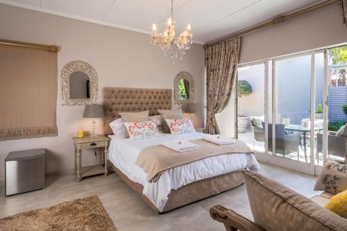 a bedroom with a large bed and a living room at La Vida Luka - Luxury Guesthouse in Pretoria