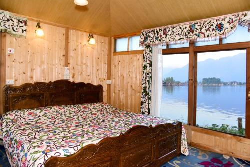 Dormitorio con cama y vistas al agua en White House Group Of Houseboats, en Srinagar