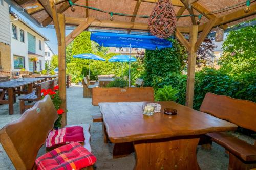 a wooden table and chairs under a wooden pergola at Gasthof Pension Walther in Weißdorf