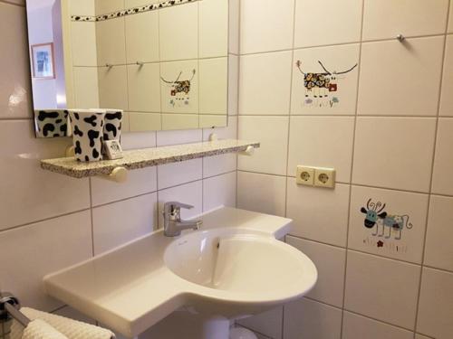 bagno bianco con lavandino e specchio di Gasthof Pension Walther a Weißdorf