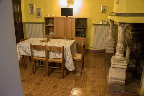 uma sala de jantar com uma mesa e algumas cadeiras em Il Camino em Anzino