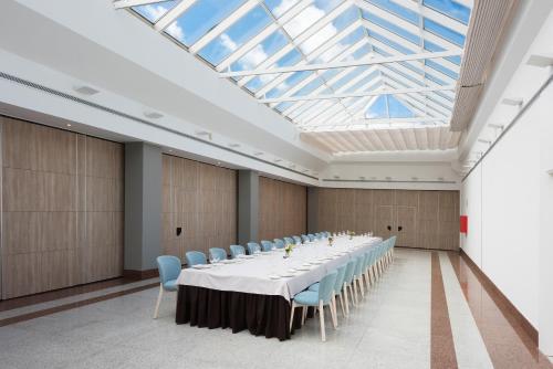 a large room with a long table and blue chairs at Hotel Guadalajara & Conference Center Affiliated by Meliá in Guadalajara