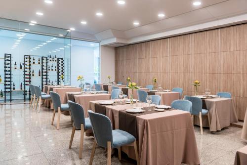a dining room with tables and blue chairs at Hotel Guadalajara & Conference Center Affiliated by Meliá in Guadalajara