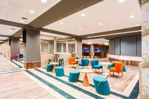 a lobby with colorful chairs and tables at Hotel Guadalajara & Conference Center Affiliated by Meliá in Guadalajara