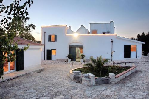 a white house with a courtyard in front of it at Dimora del Sole in Putignano