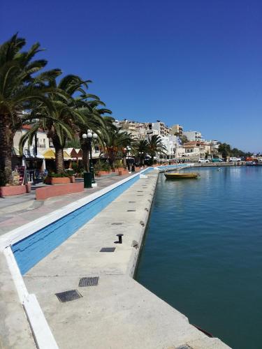 a canal of water with palm trees and a city at Nora Hotel in Sitia
