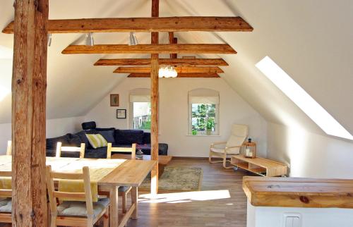 ein Wohnzimmer mit einem Tisch und einem Sofa in der Unterkunft Kleines Häuschen - Ferien in Cossebaude in Dresden