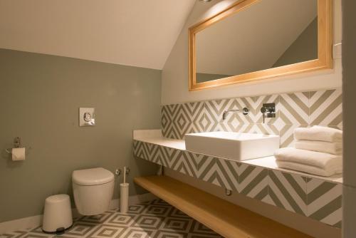 a bathroom with a sink and a mirror and a toilet at Smokvica Dorćol B&B in Belgrade