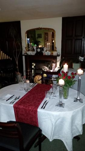 einen Tisch mit einem weißen Tischtuch und Kerzen darauf in der Unterkunft Mackworth House Farm in Derby